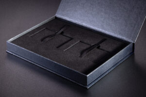 Luksusowe pudełko rigidbox na dwie karty kredytowe. Wypełnienie kartonowe kaszerowane czarnym flokiem. Tasiemki ułatwiające wyciąganie kart.  