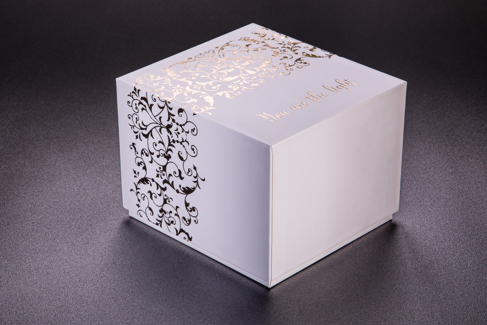 Białe pudełko ozdobne na świeczki z dużym złotym hotstampingiem. 