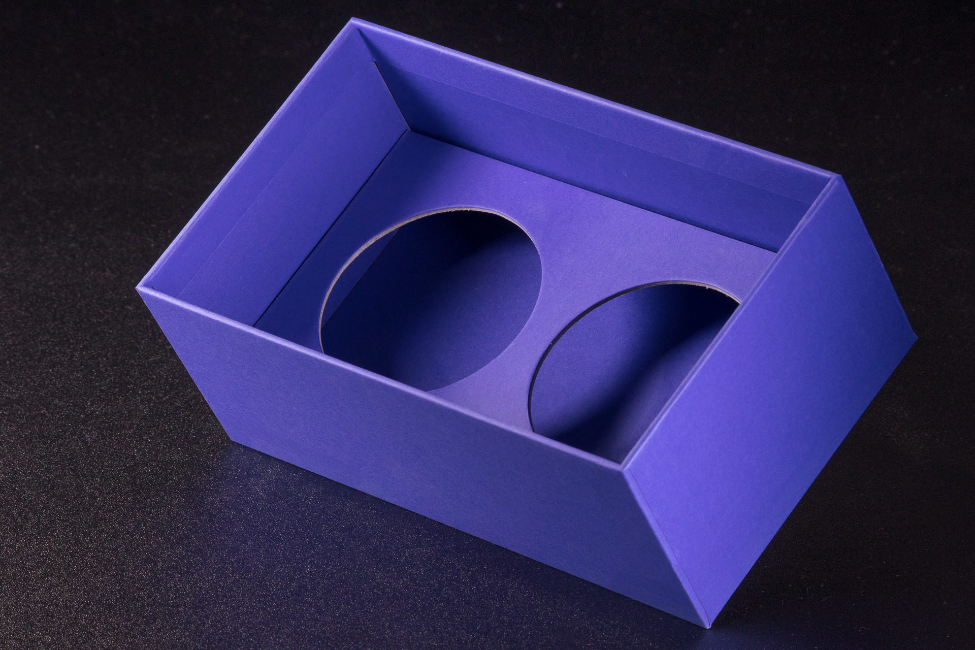 Wkładka, wypełnienie niebieskiego pudełka rigidbox wykonana z grubej, kaszerowanej tektury. Okrągłe sztancowane wycięcia na dwa słoiki. 