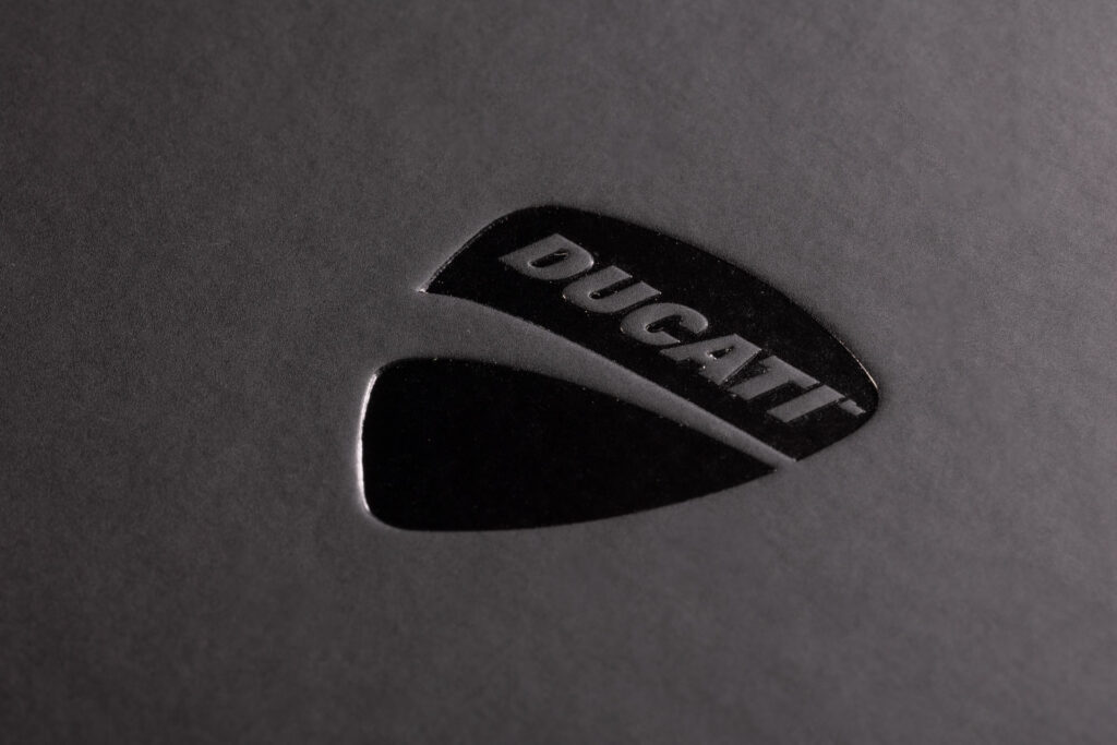 Elegancki zabieg logo w kolorze Czarny połysk na czarnym matowym materiale. Dodatkowe lekkie tłoczenie.