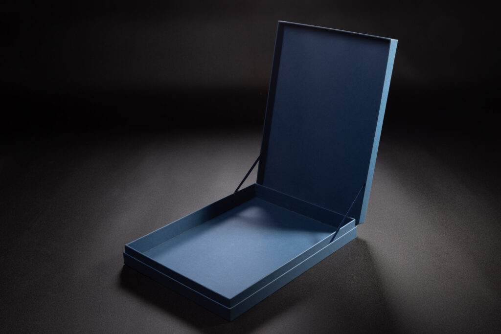 Otwarte pudełko z kapsułkowe z tasiemkami. 