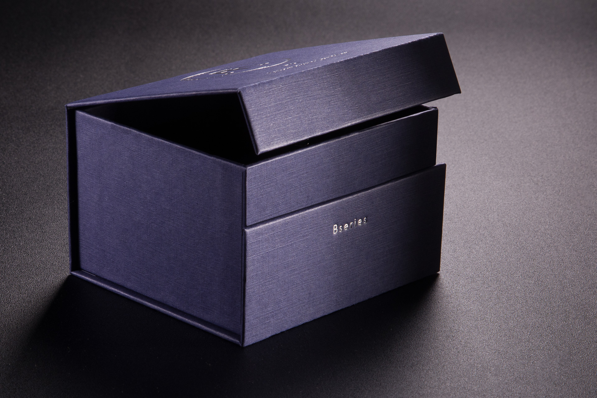 Elegancki, intrygijący efekt. Nietypowy podział klapki zamykającej pudełko. Hor stamping w dolnej części.